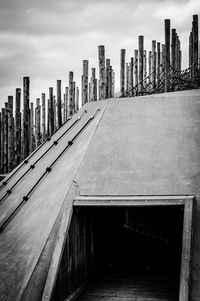 Modern bridge over river by buildings against sky