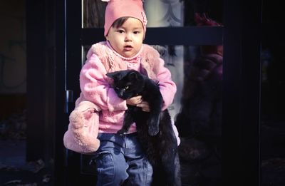 Cute girl holding cat on street