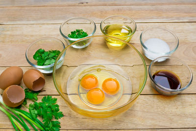 High angle view of egg yolks with various ingredients on table