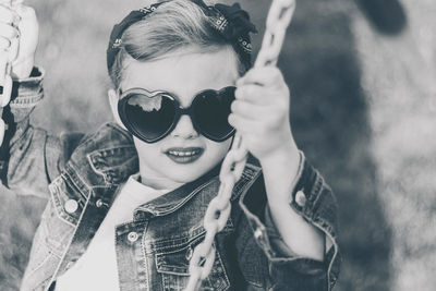Close-up portrait of girl in sunglasses holding chain