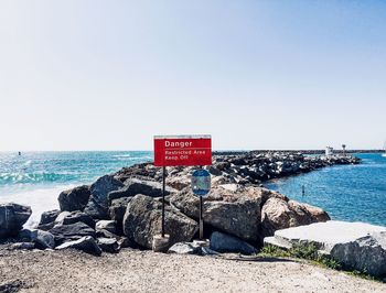 Scenic view of rocky beach against clear sky