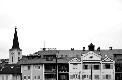 Buildings and church against clear sky