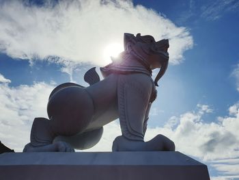 Low angle view of woman sitting against sky