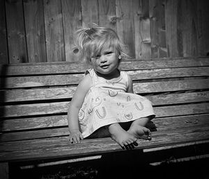 Portrait of cute girl sitting on a bench