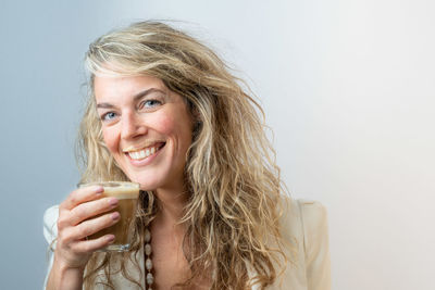 Portrait of a smiling young woman against white background