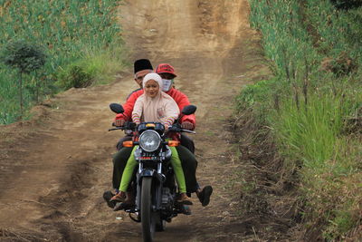 Rear view of man riding motorcycle on road