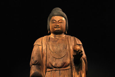 Low angle view of statue against black background