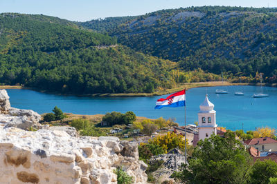 Buildings by sea against mountain