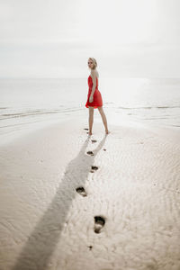 Full length of woman standing at beach