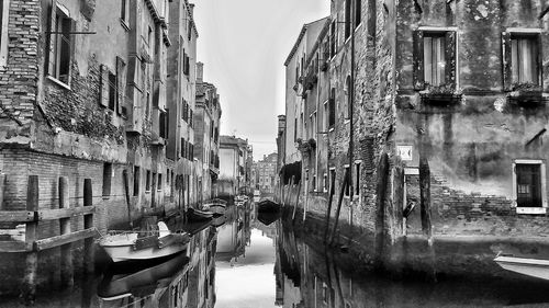 Boats in canal along buildings