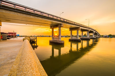 Bridge over river against sky during sunset