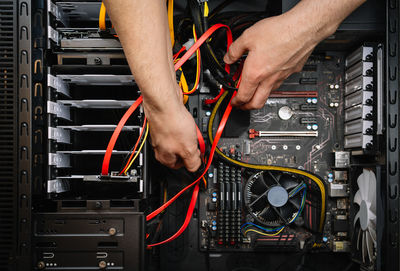 Low angle view of man working on computer cables