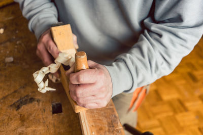 Midsection of man working on wood