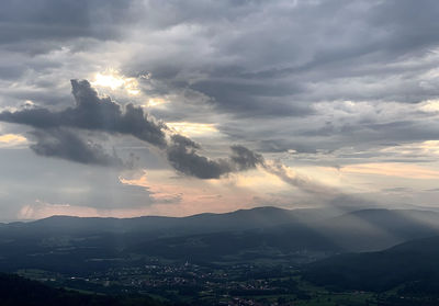 Sunlight streaming through clouds over landscape