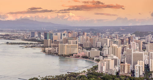 High angle view of city by sea against sky