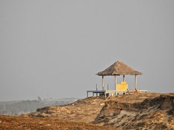 Hut on beach against clear sky