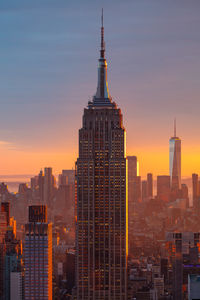 Buildings in city against sky during sunset