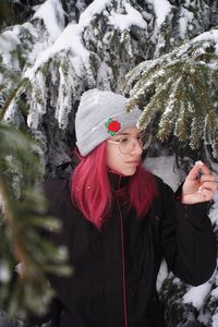 Young woman in snow covered tree