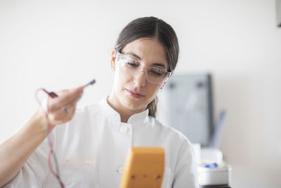 Scientist female with lab glasses, tablet and sample in a lab