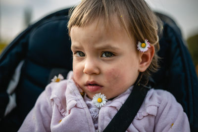 Close up portrait of little child with blond hair and small flowers