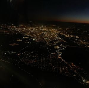 High angle view of illuminated city against sky at night