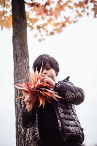Side view of young woman holding flower