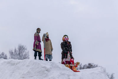 People on snow covered against sky