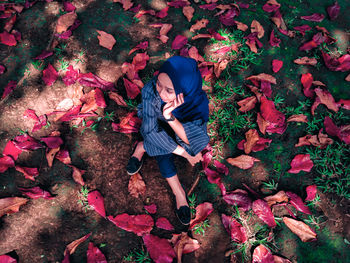 High angle view of woman with autumn leaves