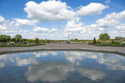 Reflection of trees on swimming pool against sky