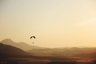 Parachute over mountains against clear sky