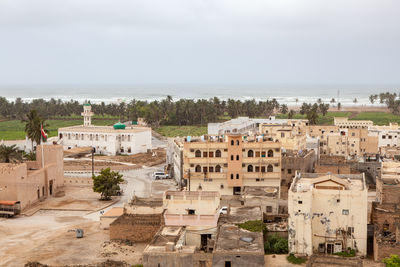 High angle view of townscape by sea against sky