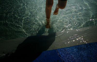 Low section of man walking in water