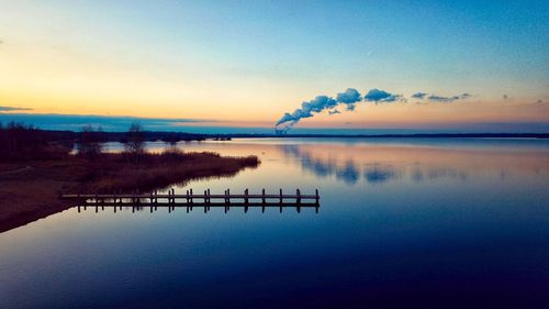 Scenic view of lake against sky at sunset