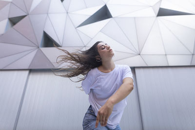 Young woman dancing with passion and energy in the street