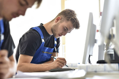 Side view of a man working on table