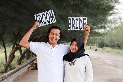 Young couple with text on roadside