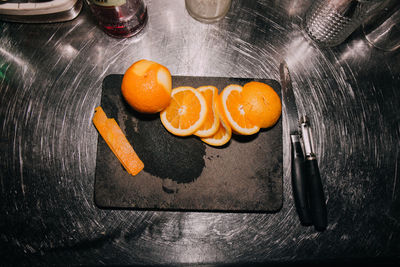 High angle view of orange slices on cutting board at table