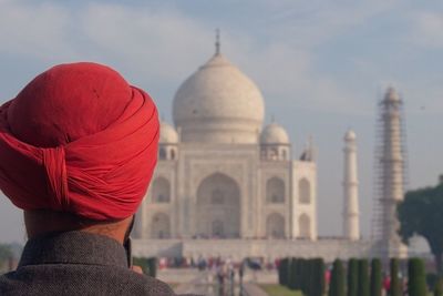 Rear view of man wearing red turban against taj mahal