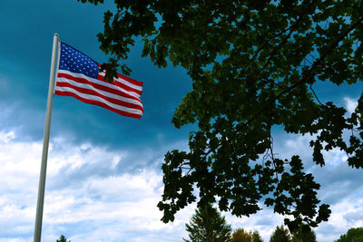 Low angle view of american flag against blue sky