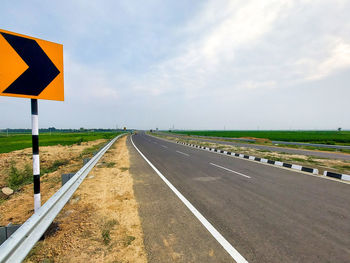 Road sign against sky