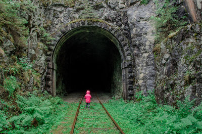 Rear view of woman standing in tunnel