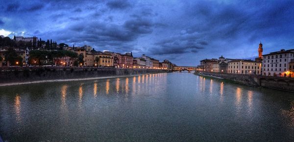 View of river in old town against cloudy sky