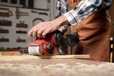 Midsection of man working in workshop