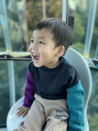 Portrait of asian boy looking away in cable car with happy face