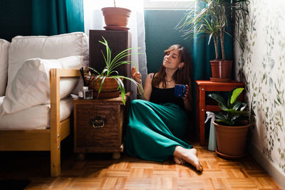 Young woman sitting on sofa at home