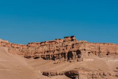 View of rock formations against clear blue sky