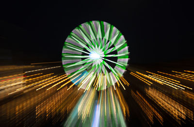 Low angle view of illuminated ferris wheel against sky at night