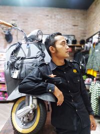 Side view of young man looking away on street in city