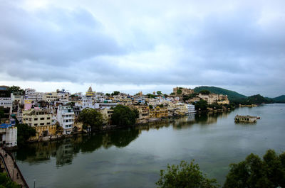 River in town against cloudy sky