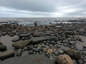 Rocks on beach against sky